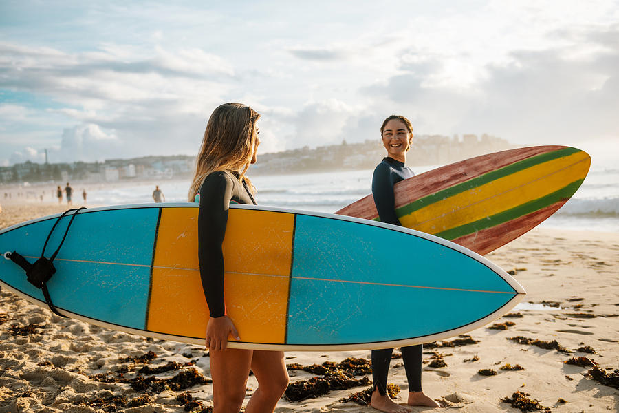 Two female friends with surfboards Photograph by Drazen_