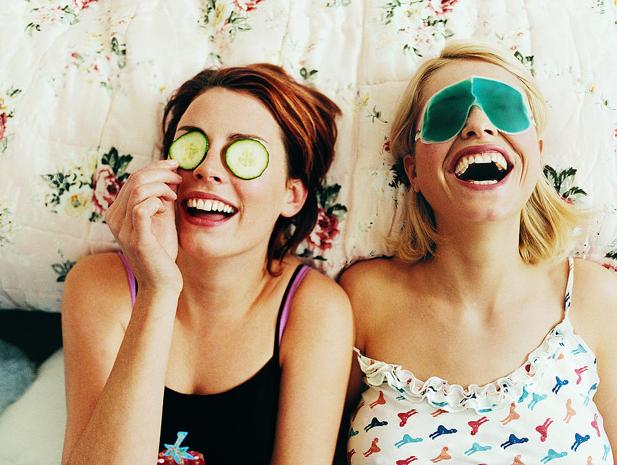 Two Female Teenagers Lying in Bed Wearing Eye Masks Photograph by Digital Vision.