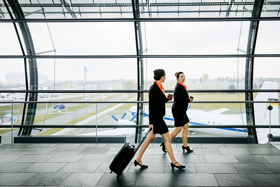 Two flight attendants on the way to their plane Photograph by Hinterhaus Productions