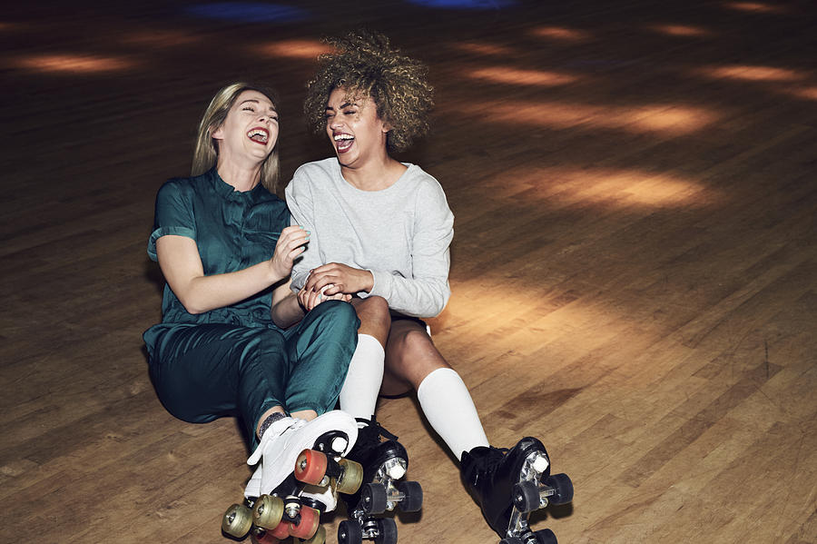 Two friends having fun at roller disco Photograph by Flashpop