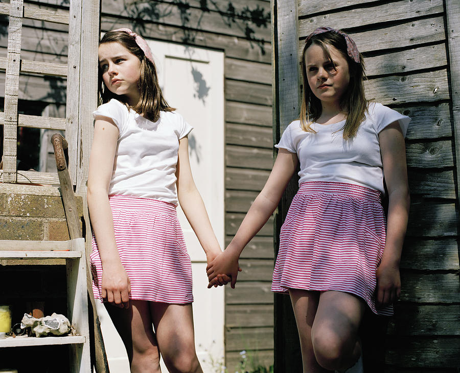 Two Girls in Identical Outfits Holding Hands Photograph by Alys Tomlinson