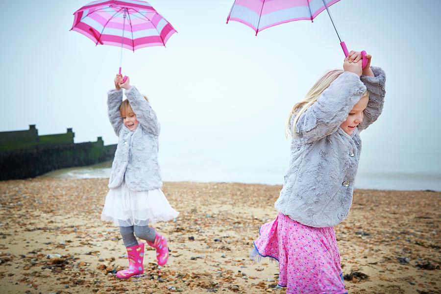 Two Girls On Beach Holding Umbrellas Photograph by Ruth Jenkinson