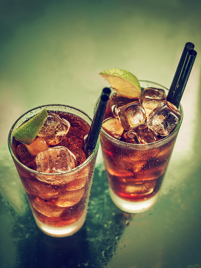Two glasses of cold rum cola Photograph by StudioThreeDots