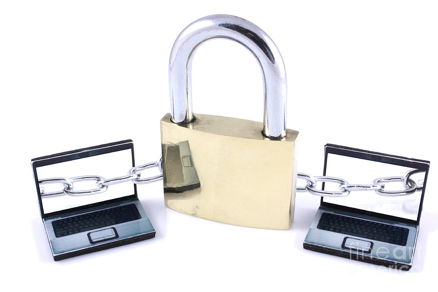 Two laptops chained to a large padlock Photograph by Simon Bratt