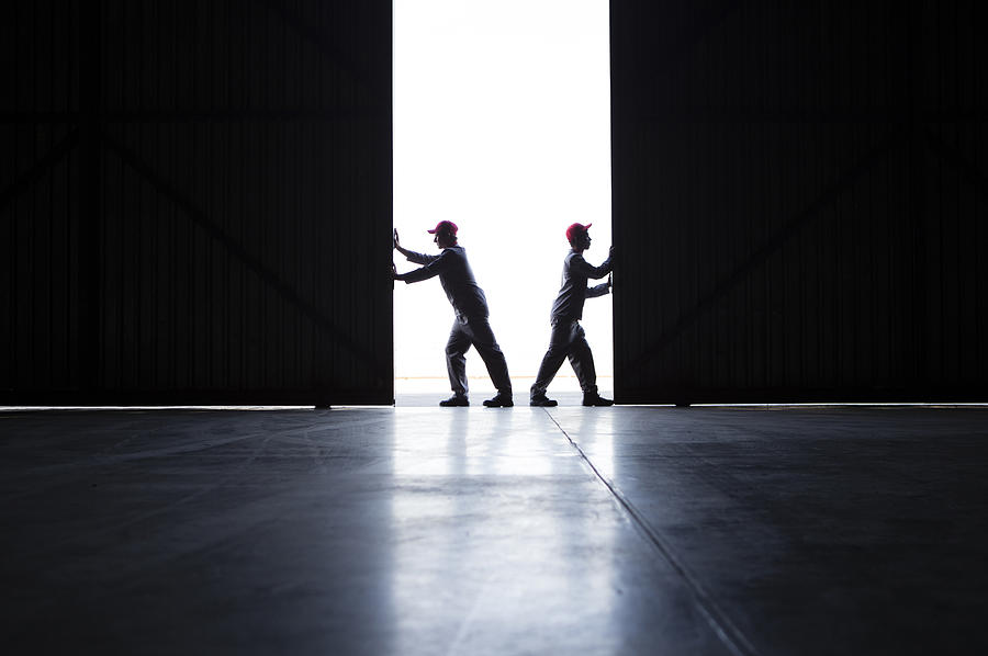 Two men pushing open doors Photograph by Alistair Berg