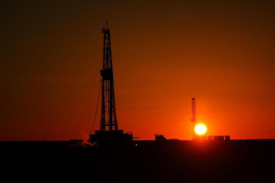 Sunset Photograph - Two Oil Rigs In The Twilight by Jeff Swan