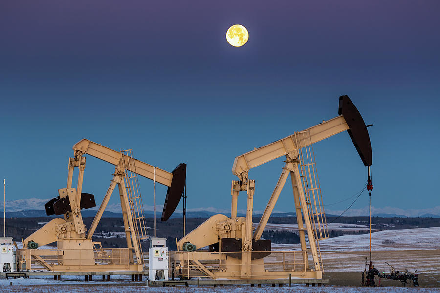 Two Pump Jacks At Dusk In A Snow Photograph by Michael Interisano