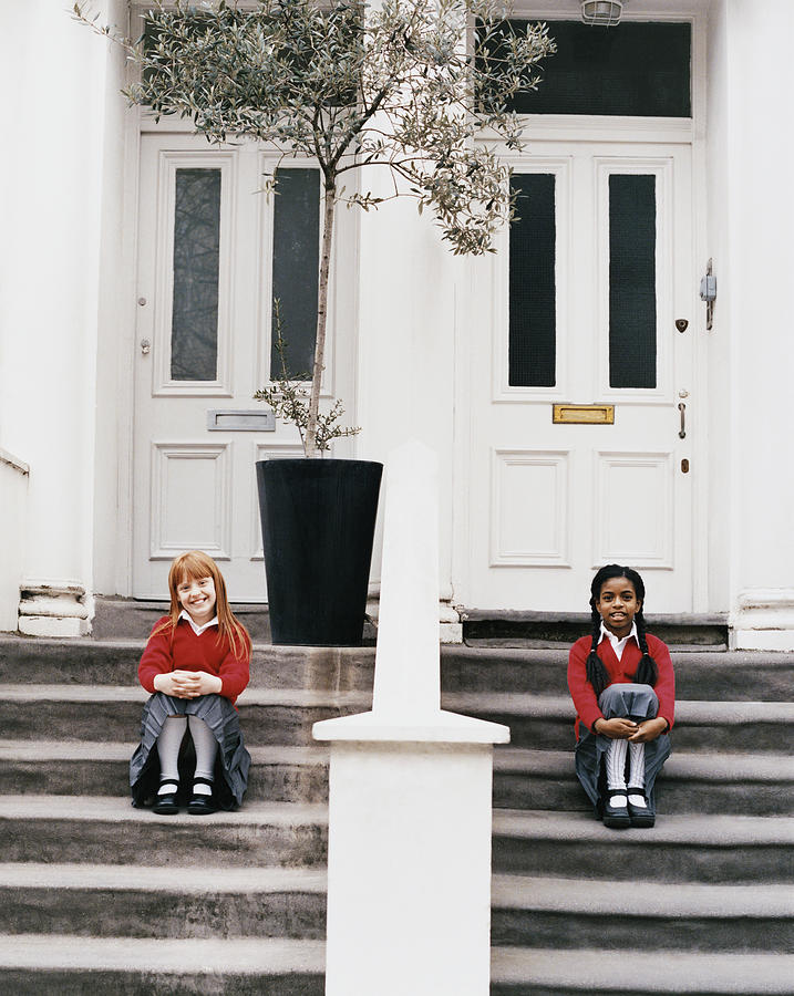 Two Schoolgirls Sitting on Steps In Front of Their Houses Photograph by Lottie Davies