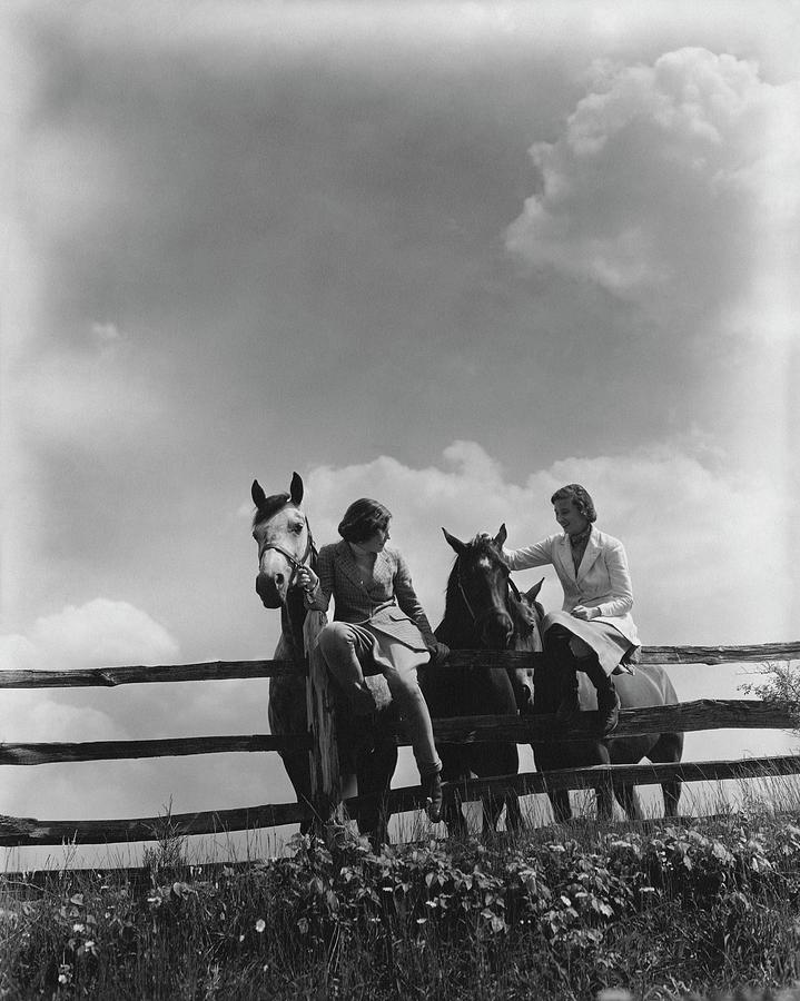 Two Women Sitting On A Fence With Horses Photograph by Lusha Nelson