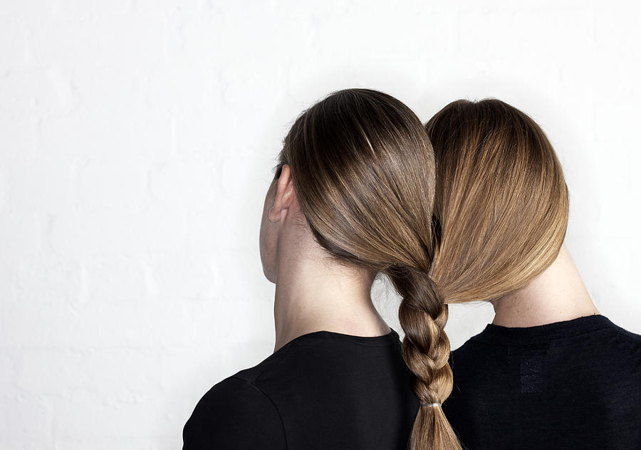 Two women tied together by hair plait Photograph by Compassionate Eye Foundation/Andrew Olney/OJO Images Ltd