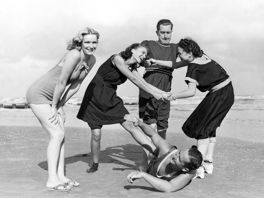 Black And White Photograph - Two Women Tussle On The Beach by Underwood Archives