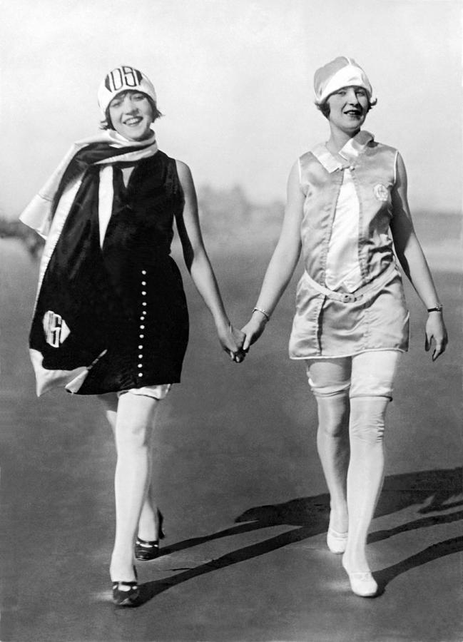 Black And White Photograph - Two Women Walking On Beach by Underwood Archives