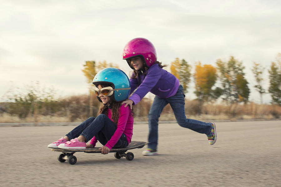 Two Young Girls Race on Skateboard Photograph by RichVintage