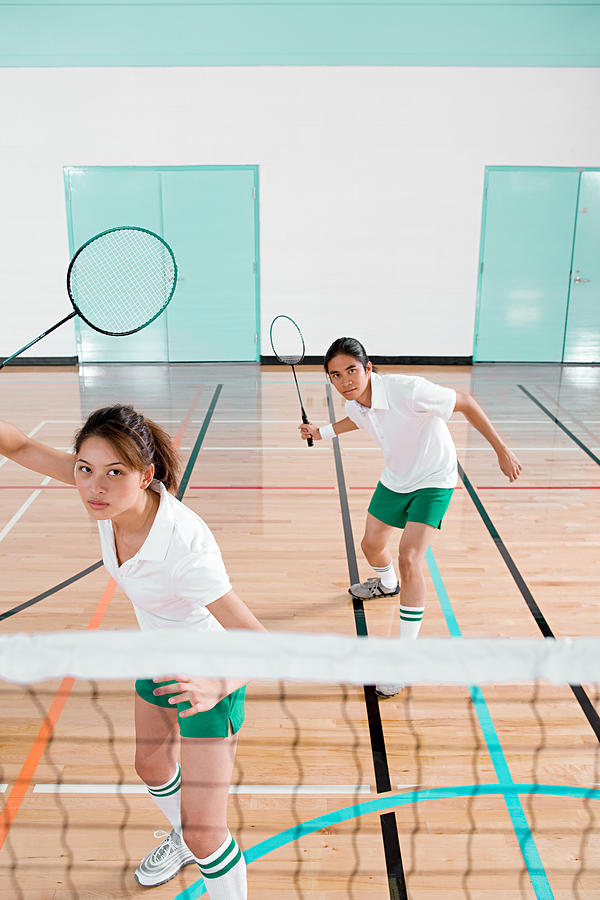 Two young people playing badminton Photograph by Image Source