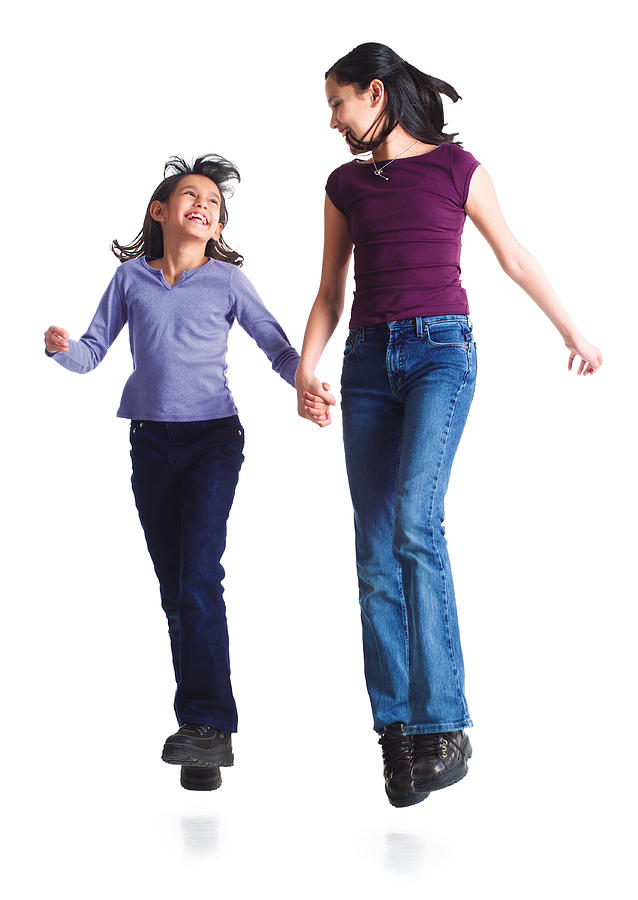 Two Young Sisters Jump Into The Air Laughing While Holding Hands Photograph by Photodisc