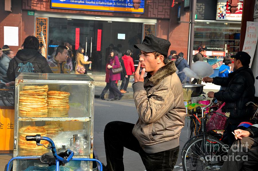Uighur street side bread vendor smokes Shanghai China Photograph by Imran Ahmed