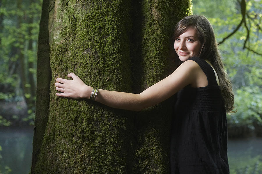 UK, Mells, Somerset, young woman hugging tree in forest, portrait Photograph by Tim Robberts