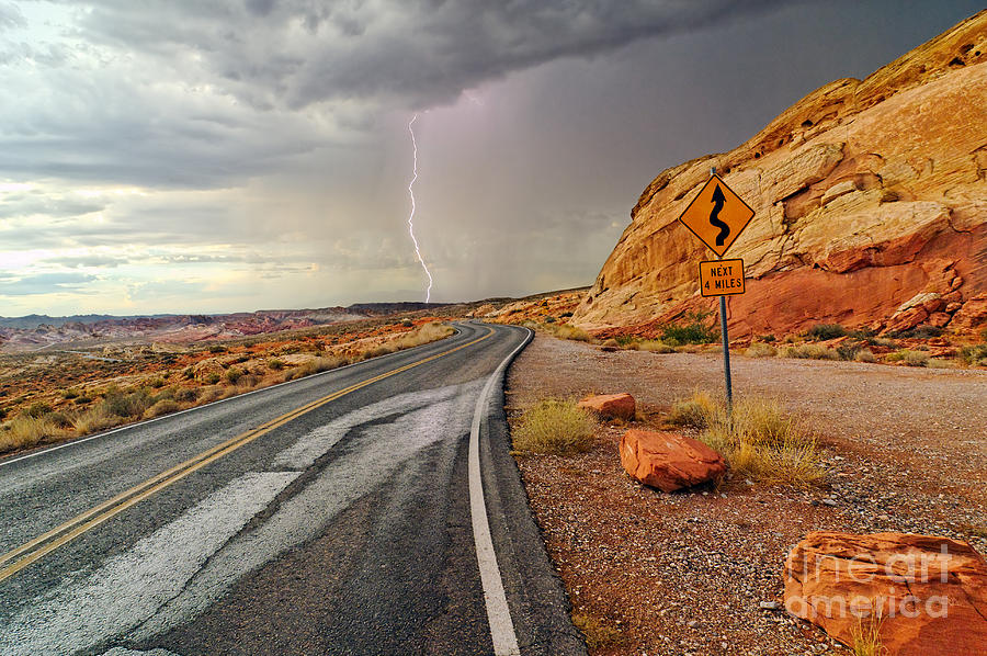 Desert Photograph - Uncertainty - Lightning striking during a storm in the Valley of Fire State Park in Nevada. by Jamie Pham