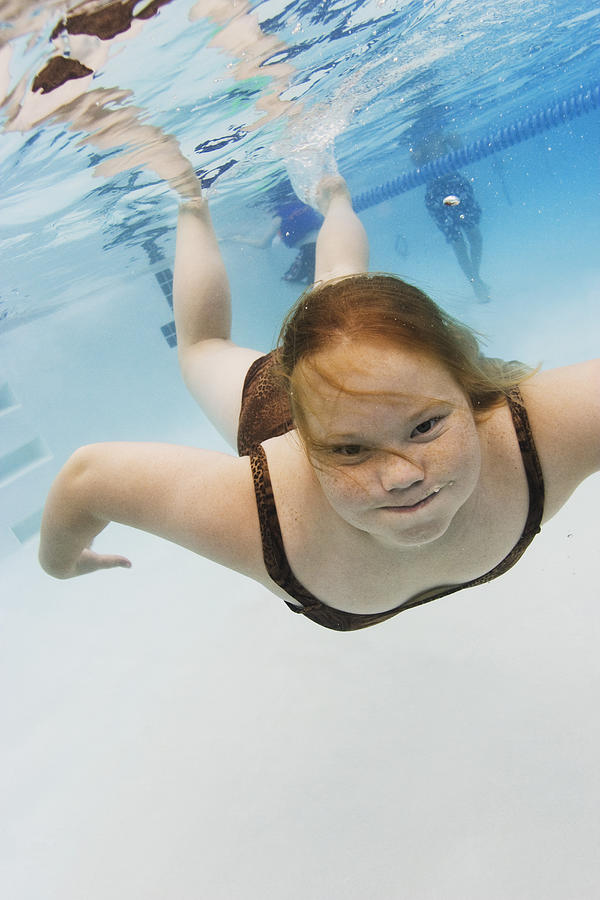 Underwater Lifestyle Shot Of A Female Child In A Swimsuit As She Swims And Plays In A Pool Photograph by Photodisc