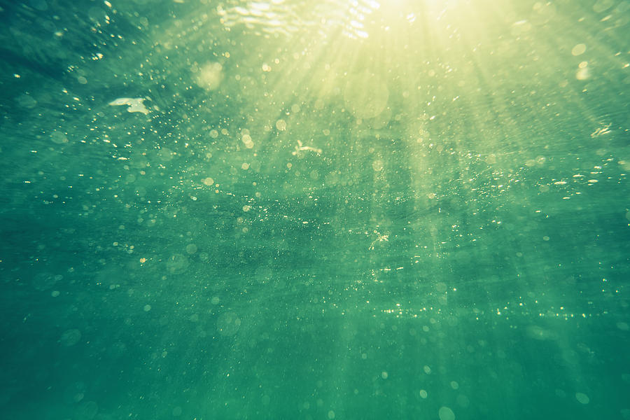 Underwater shot with sunrays and bubbles in deep tropical sea Photograph by Valio84sl