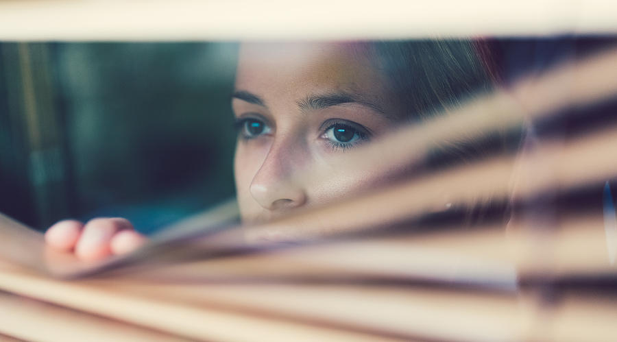 Unhappy woman looking through the window Photograph by Martin-dm