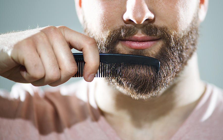 Unrecognizable man combing his beard Photograph by Gilaxia