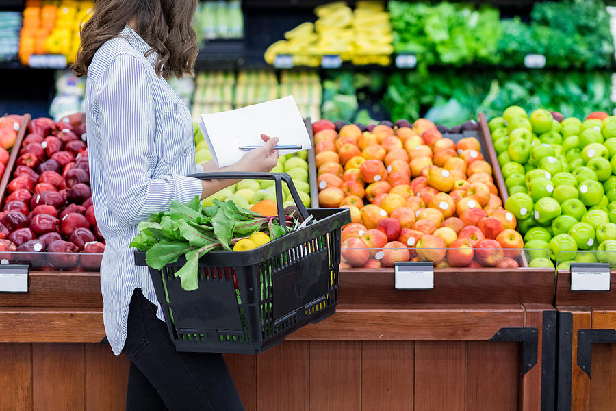 Unrecognizable woman shops for produce in supermarket Photograph by Steve Debenport