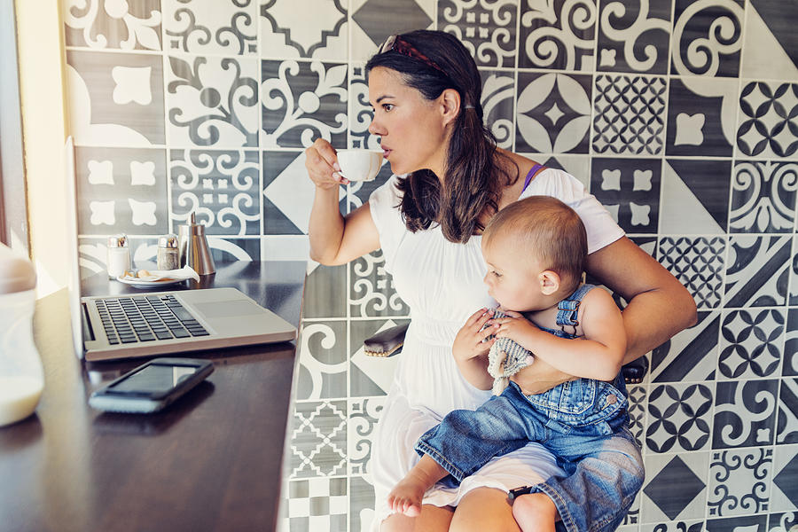 Urban mom balancing work and family in a public cafe. Photograph by Martinedoucet