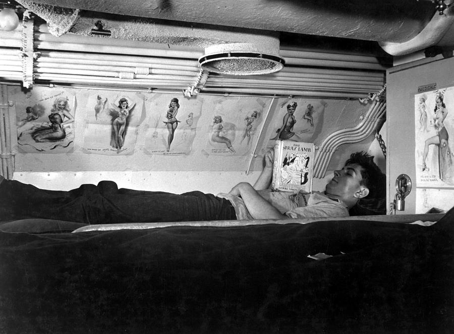 U.s. Sailor Reading In His Bunk Aboard Photograph by Everett