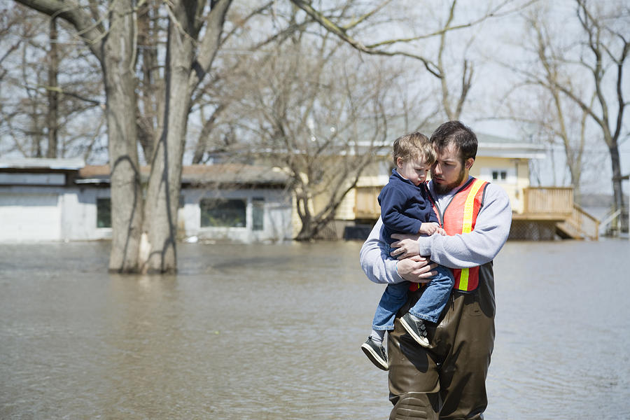 USA, Illinois, Man with son wading in floodwaters Photograph by Greg Vote