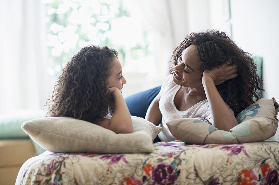USA, New Jersey, Jersey City, Mother with daughter (8-9) talking on bed Photograph by Tetra Images