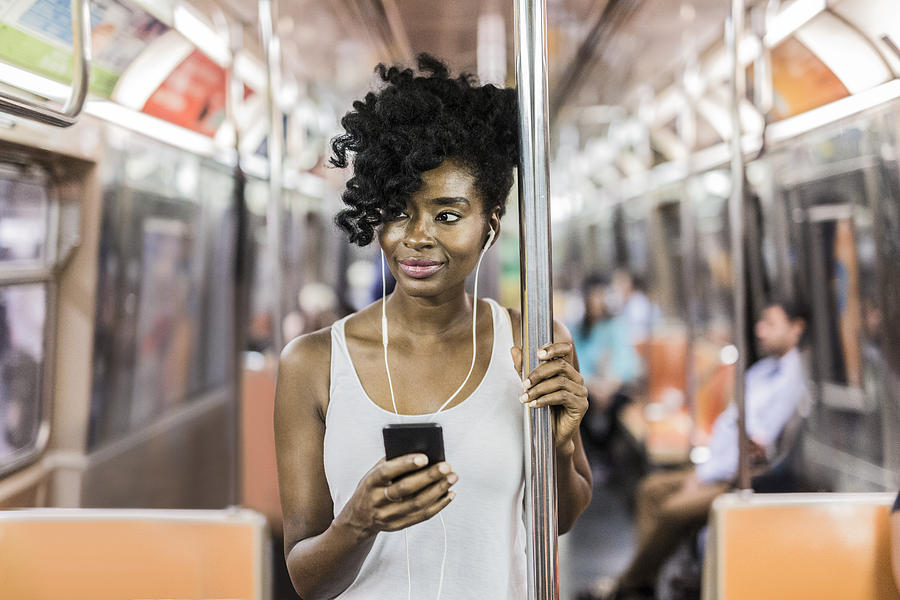 USA, New York City, Manhattan, portrait of relaxed woman with cell phone in underground train Photograph by Westend61