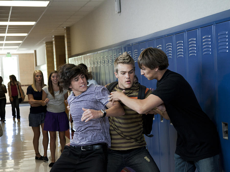 USA, Utah, Spanish Fork, Three boys (16-17) fighting in school corridor Photograph by Weston Colton