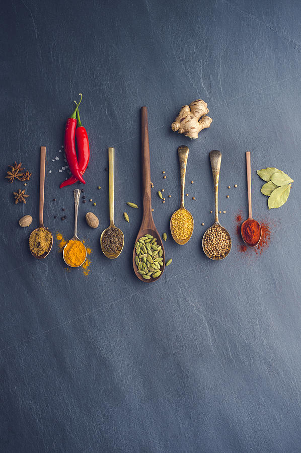 Variety of herbs and spices on slate background. Photograph by Courtneyk