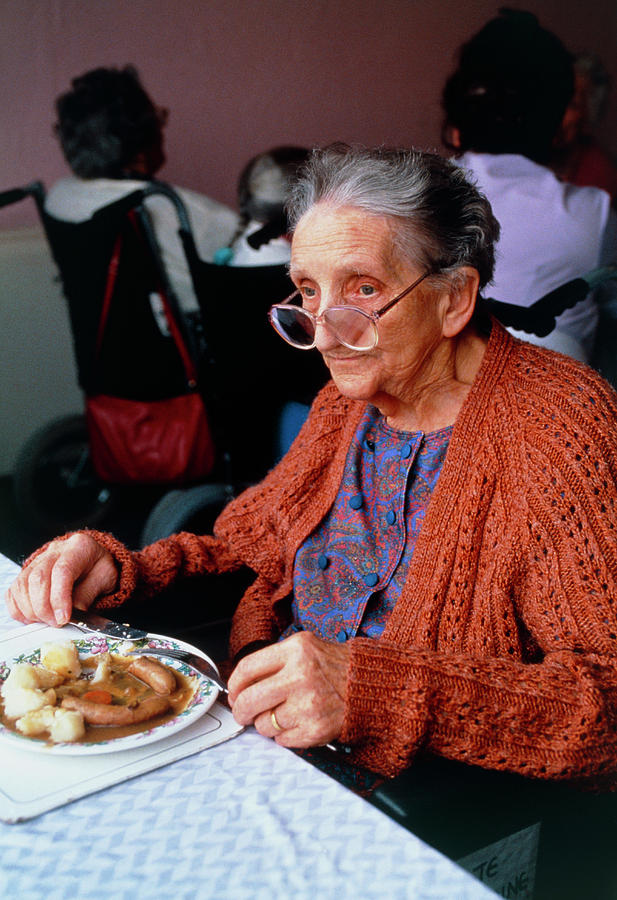 View Of An Elderly Woman Eating Her Dinner Photograph by Mark Allan/science Photo Library