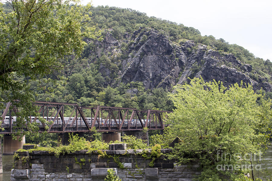 View over an old bridge pier show railroad bridges and cliffs at Harpers Ferry West Virginia Photograph by William Kuta