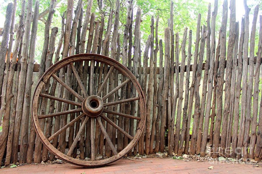 Vintage Wagon Wheel And Log Fence Photograph