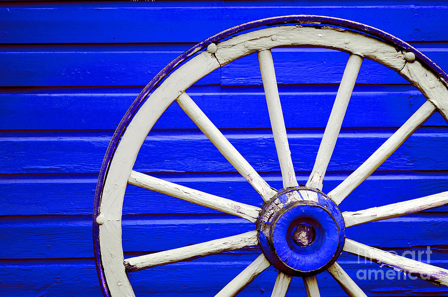 Wagon Wheel By Painted Blue Wall Photograph