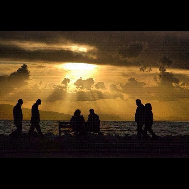 Sunset Photograph - Walking people at the seaside by Volkan Kaya