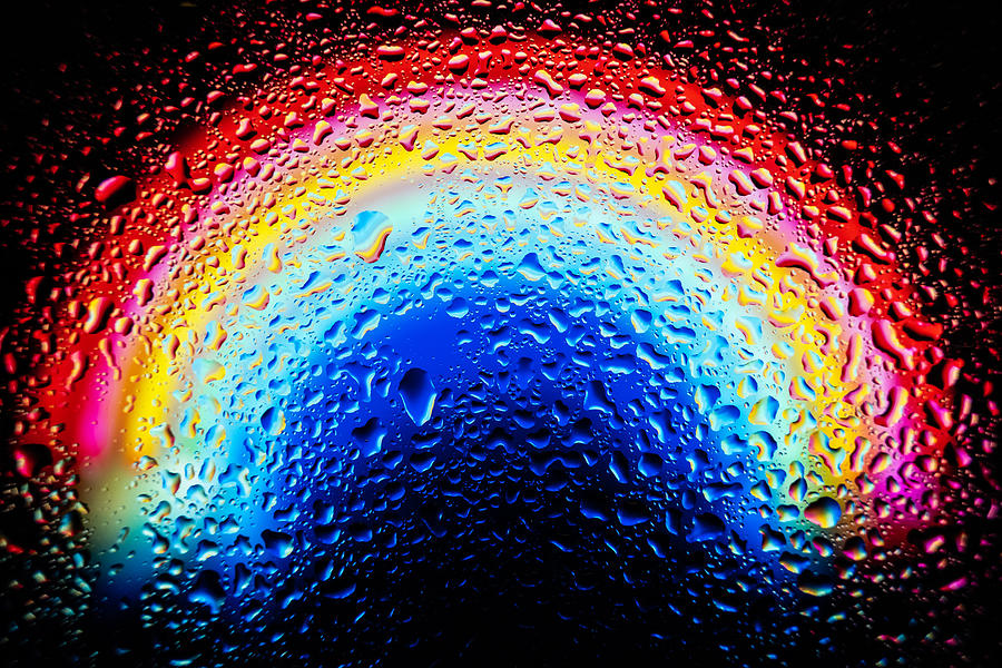 Waterdrops on window glass with colorful abstract background . Photograph by Kiszon Pascal
