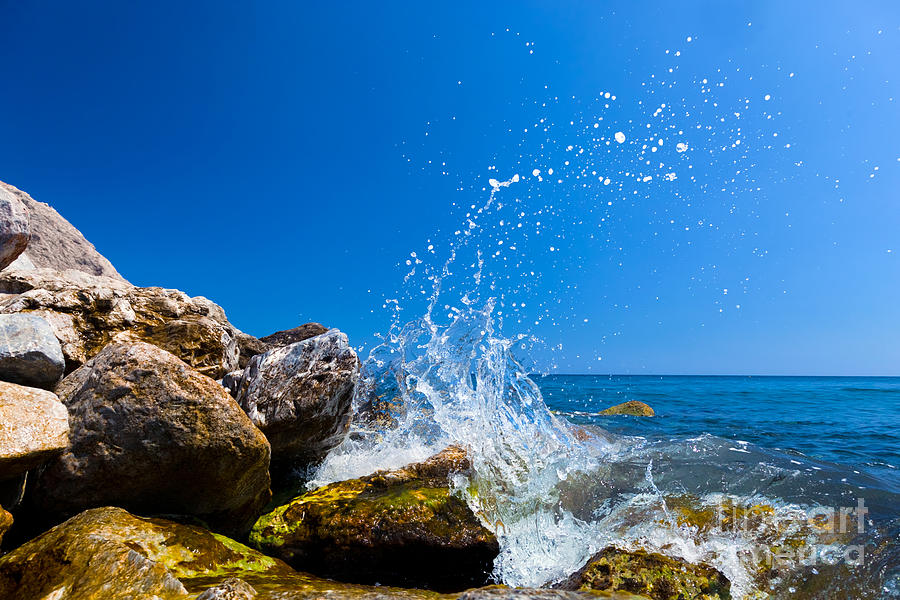 Waves hitting rocks on a tropical beach Greece Santorini Photograph by Michal Bednarek
