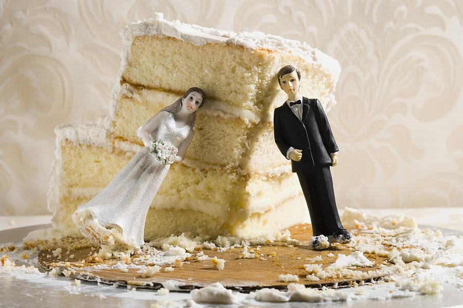 Wedding cake visual metaphor with figurine cake toppers Photograph by Rubberball/Mike Kemp