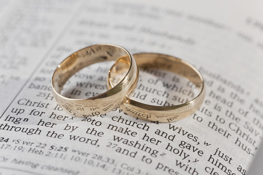 Wedding rings on top of an open bible Photograph by Vstock LLC