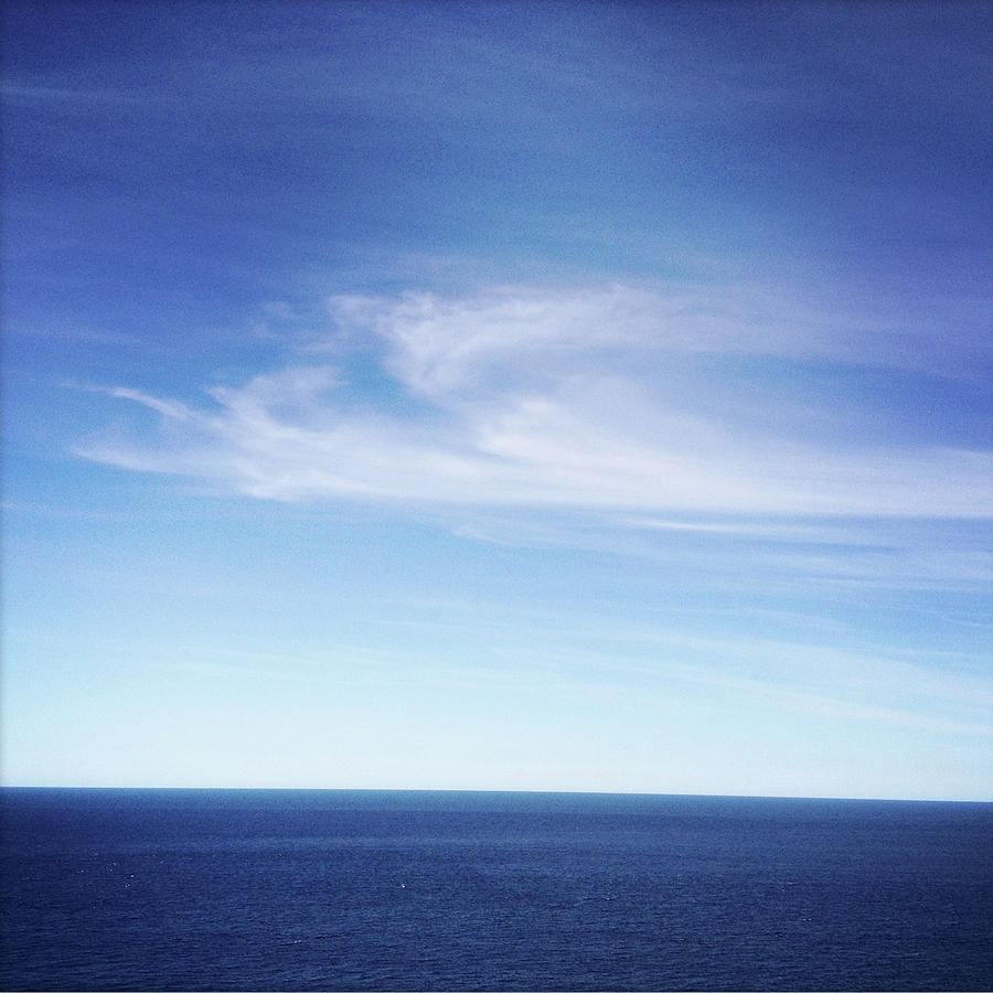 Whispy Clouds Over A Deep Blue Ocean Photograph by Jodie Griggs