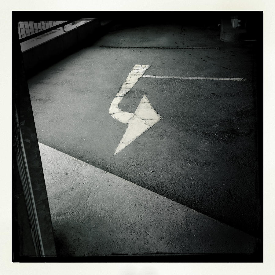 Black And White Photograph - White arrow on dark asphalt by Matthias Hauser