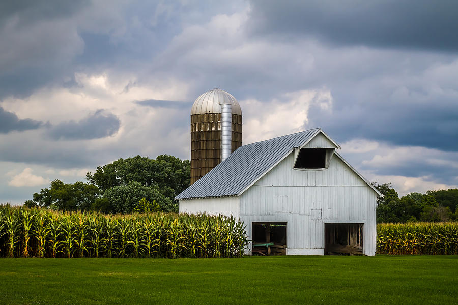 White Barn and Silo with Storm Clouds Photograph by Ron Pate