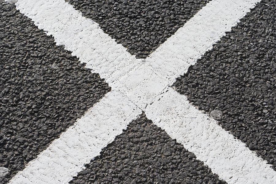 White cross shape on tarmac road Photograph by Background Abstracts