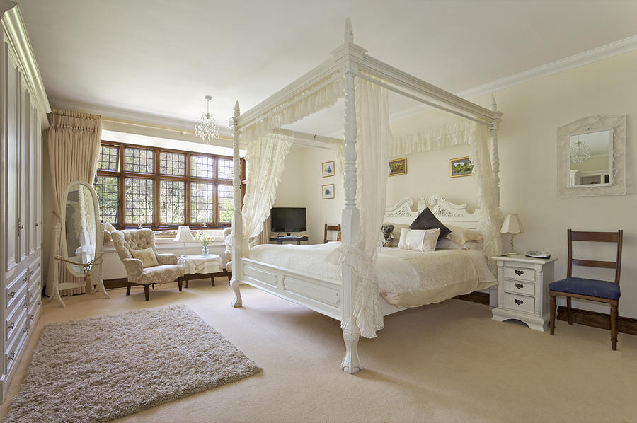 White four-poster bed in large neutral-colored bedroom Photograph by Phototropic