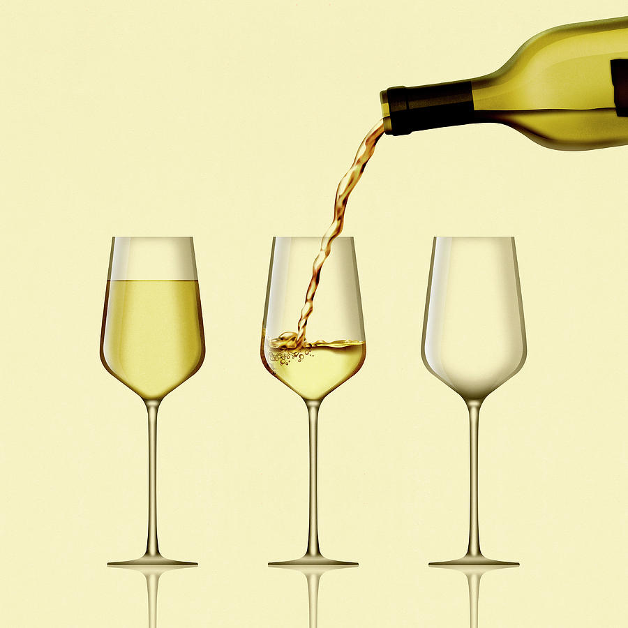 White Wine Being Poured Into Three Wine Photograph by Ikon Ikon Images