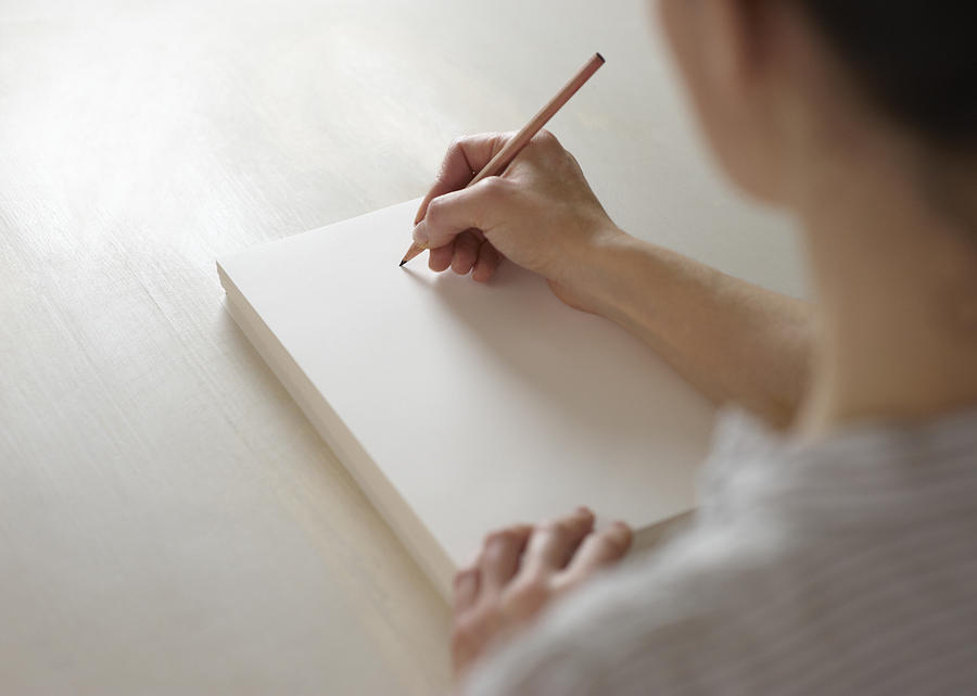 Woman about to draw on blank pad of paper Photograph by Dougal Waters